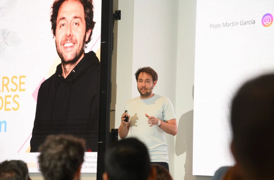 Pepe Martín García dando una charla ante el público, con su presentación proyectada al fondo